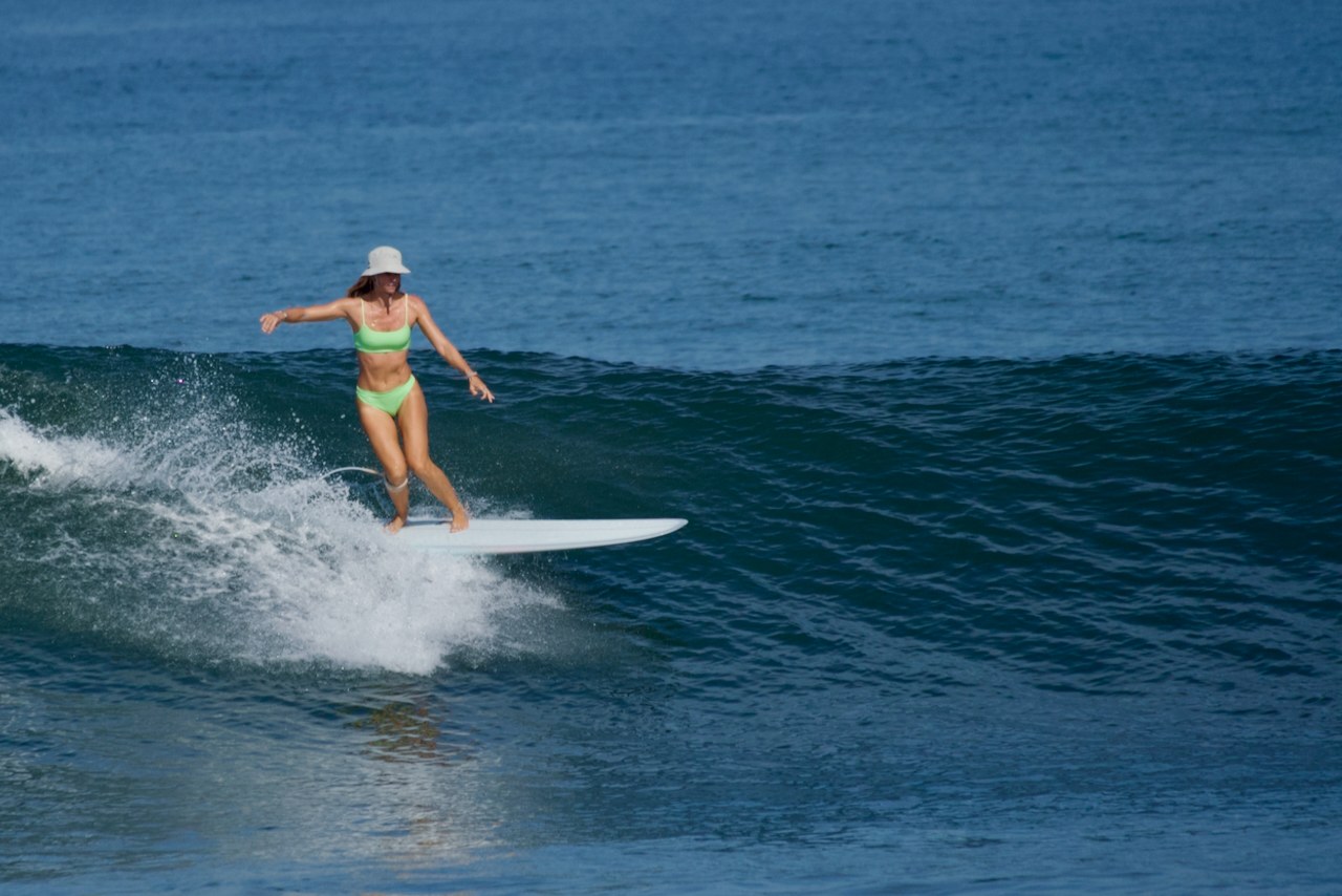 Girl surfing a longboard at Medewi Bali