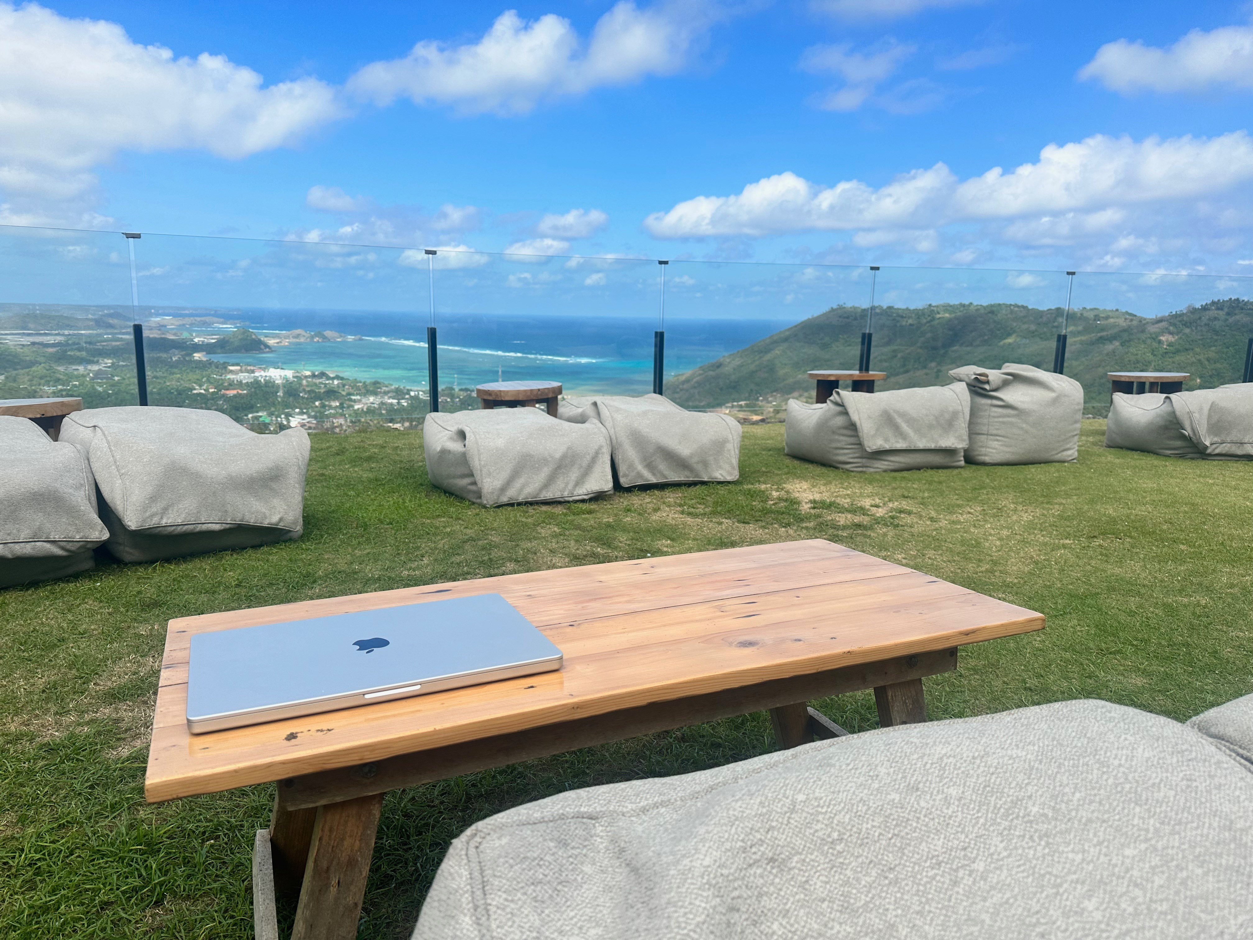 Laptop sitting on a table in Lombok with a beautiful view behind it