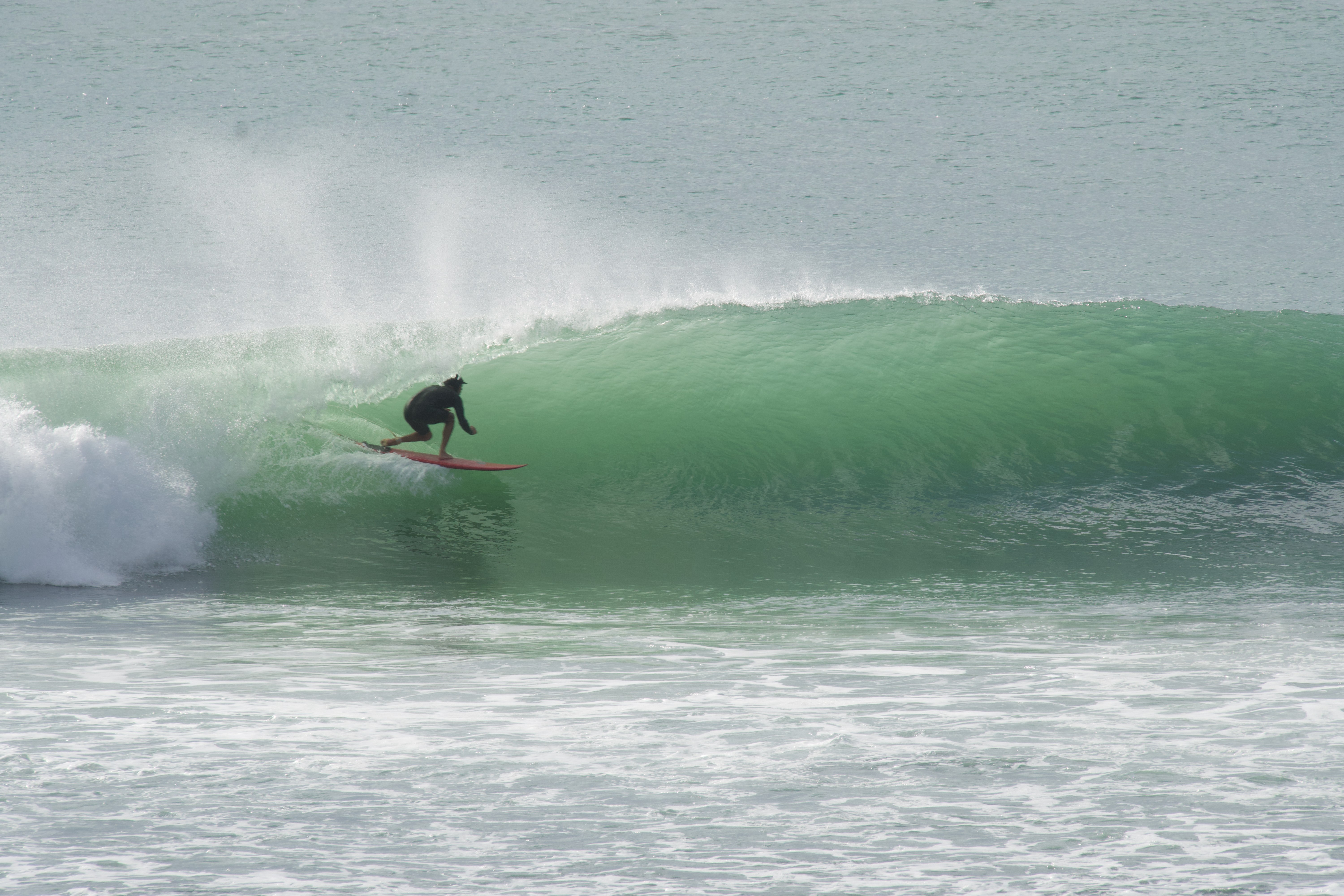 Surfer catching a wave at Bingin, Bali