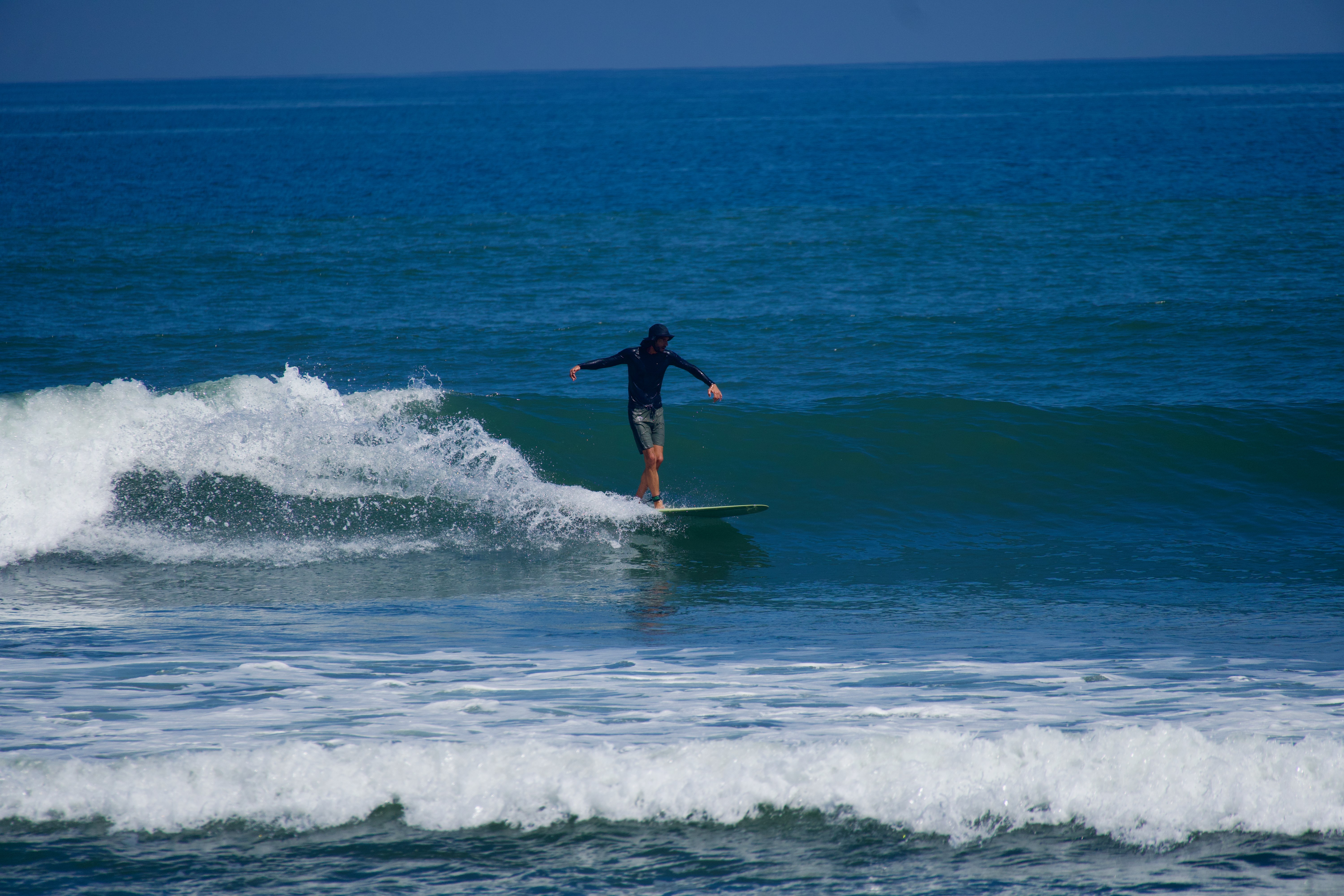 Longboarder cross stepping at Medewi